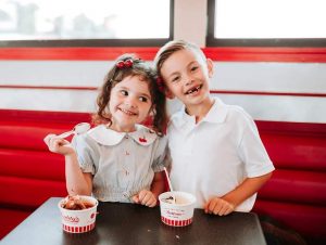 Two young children eating custard