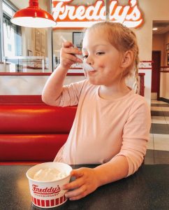 young girl eating frozen custard dish